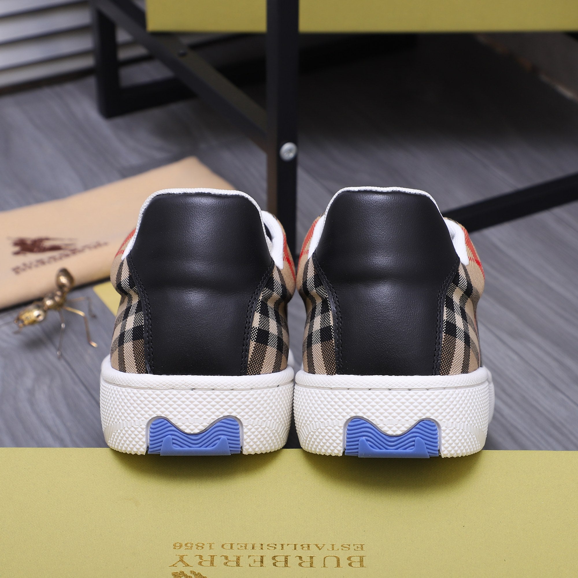 Burberry sneakers from the back with tan plaid sides and blue traction heel detail