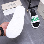White textured outsole for slide sandal, with green-logo strap visible