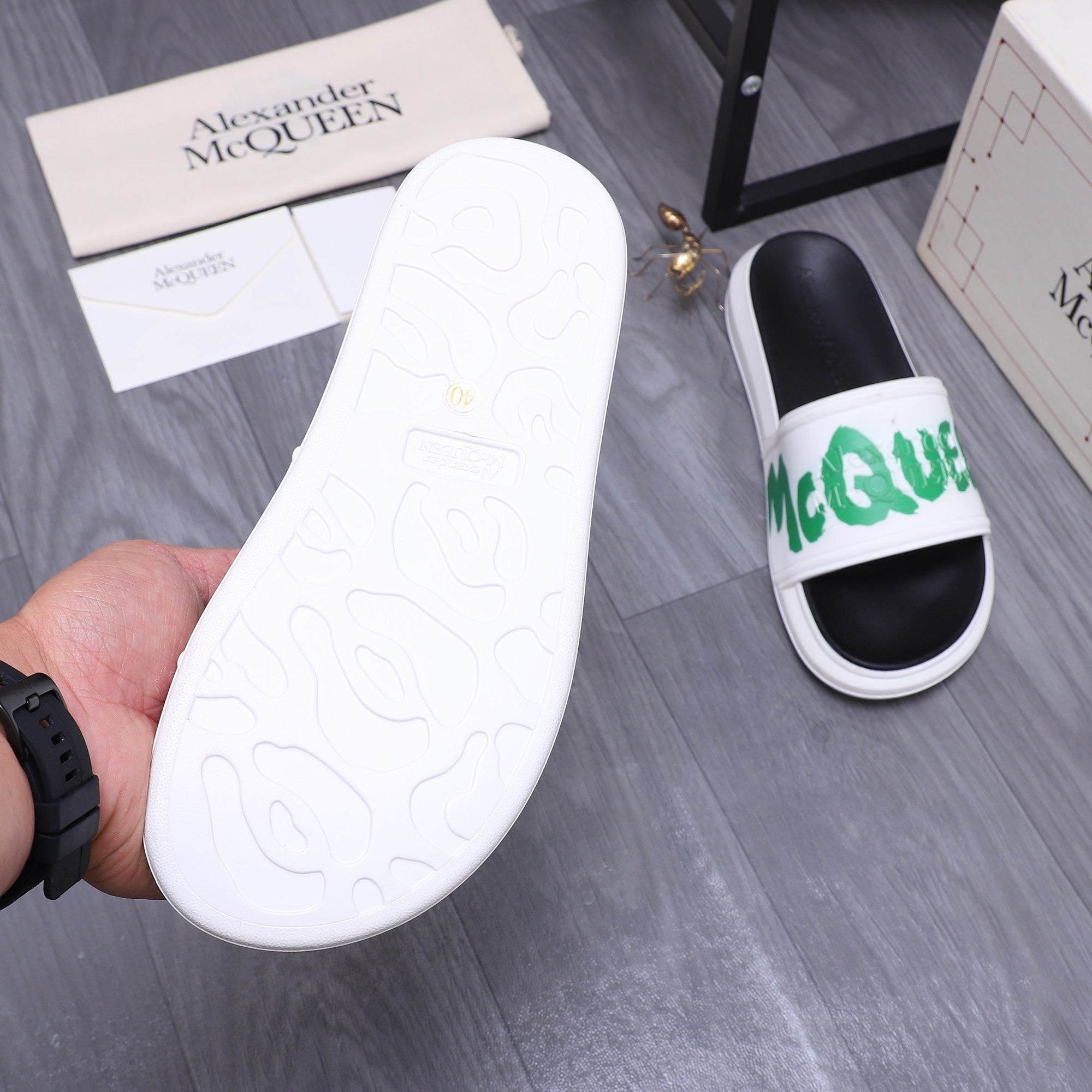 White textured outsole for slide sandal, with green-logo strap visible