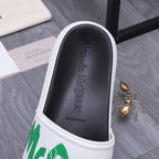 Black slide sandal footbed with embossed branding and white edge