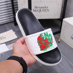 Leather slide sandal in white with red and green graphic print on black footbed.