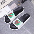 Slide sandals set: black footbeds with white straps and red-green graphic art.
