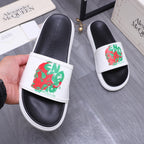 Leather slide sandal with white strap and red/green graphic print, black footbed.