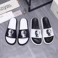 Alexander McQueen slide sandals, black strap with white portrait print, white footbed.