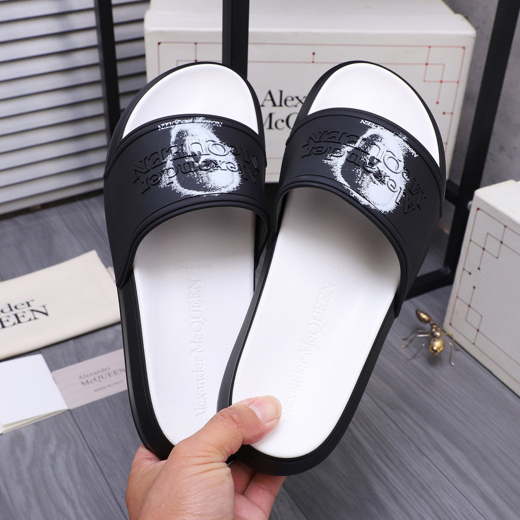 Black slide sandals with white footbed; strap shows white portrait graphic.