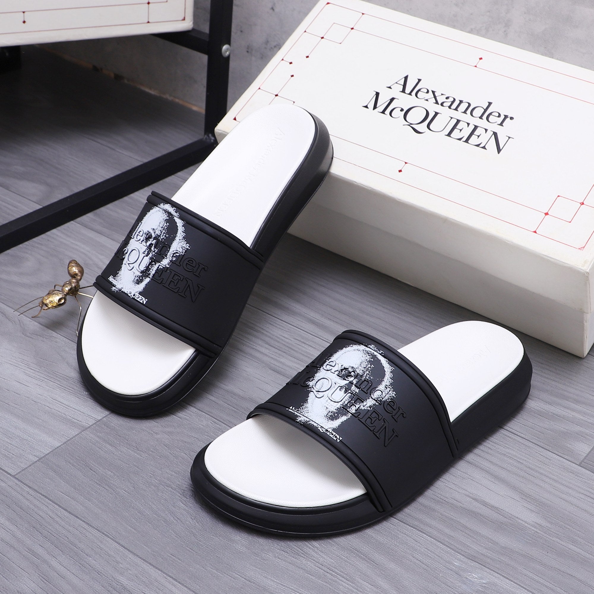 Black slide sandals with wide strap and white portrait graphic, open white footbed.