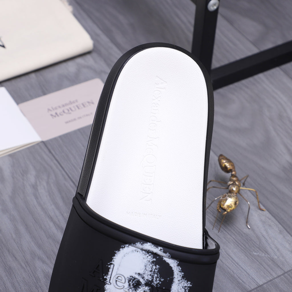 Side view of black slide sandal with white footbed and portrait graphic on strap.