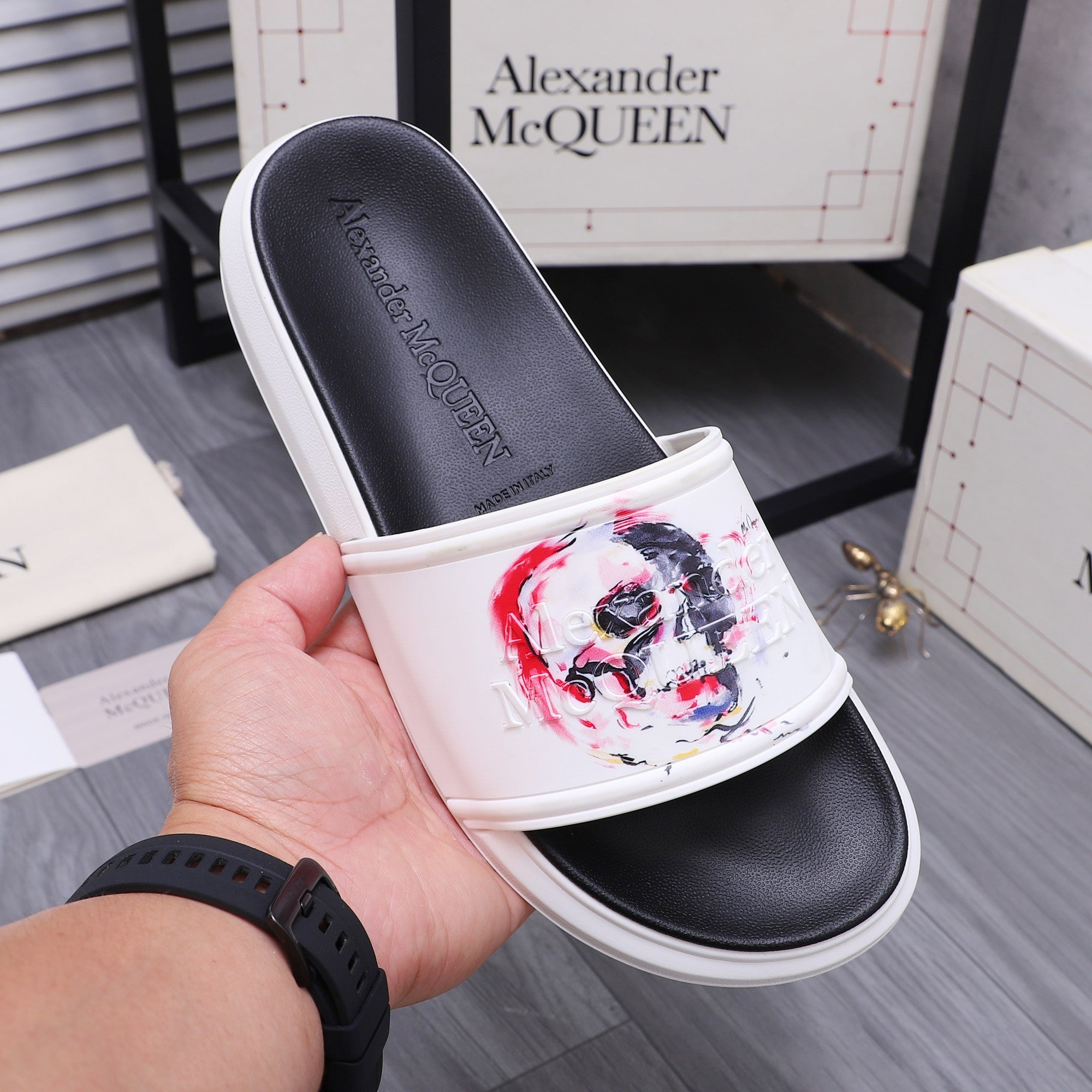 Alexander McQueen slide sandal showing toe strap and red/blue skull print on white