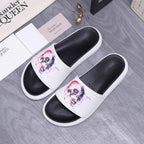 Alexander McQueen slide sandals with white straps and red/blue skull graphic