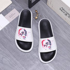 Alexander McQueen slide sandals, black footbeds with white uppers and skull graphic