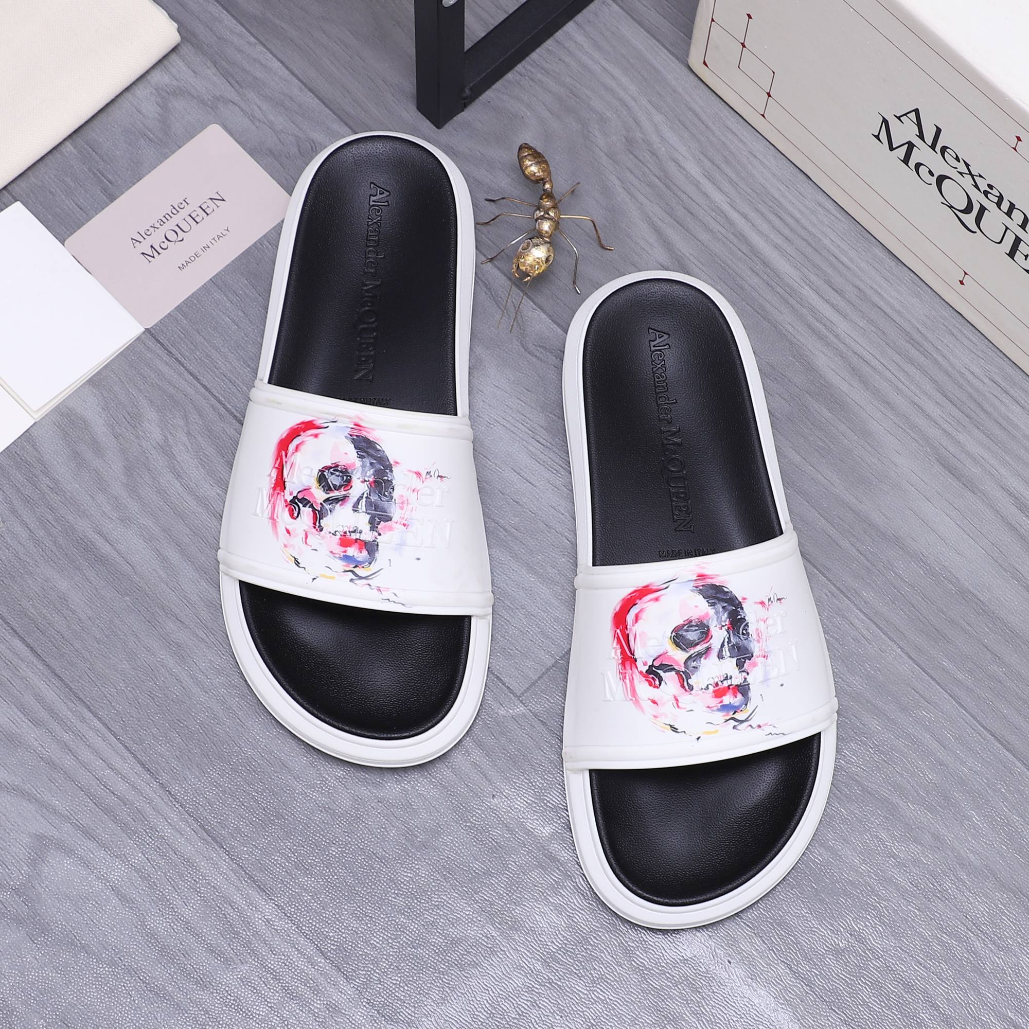 Alexander McQueen slide sandals, black footbeds with white uppers and skull graphic