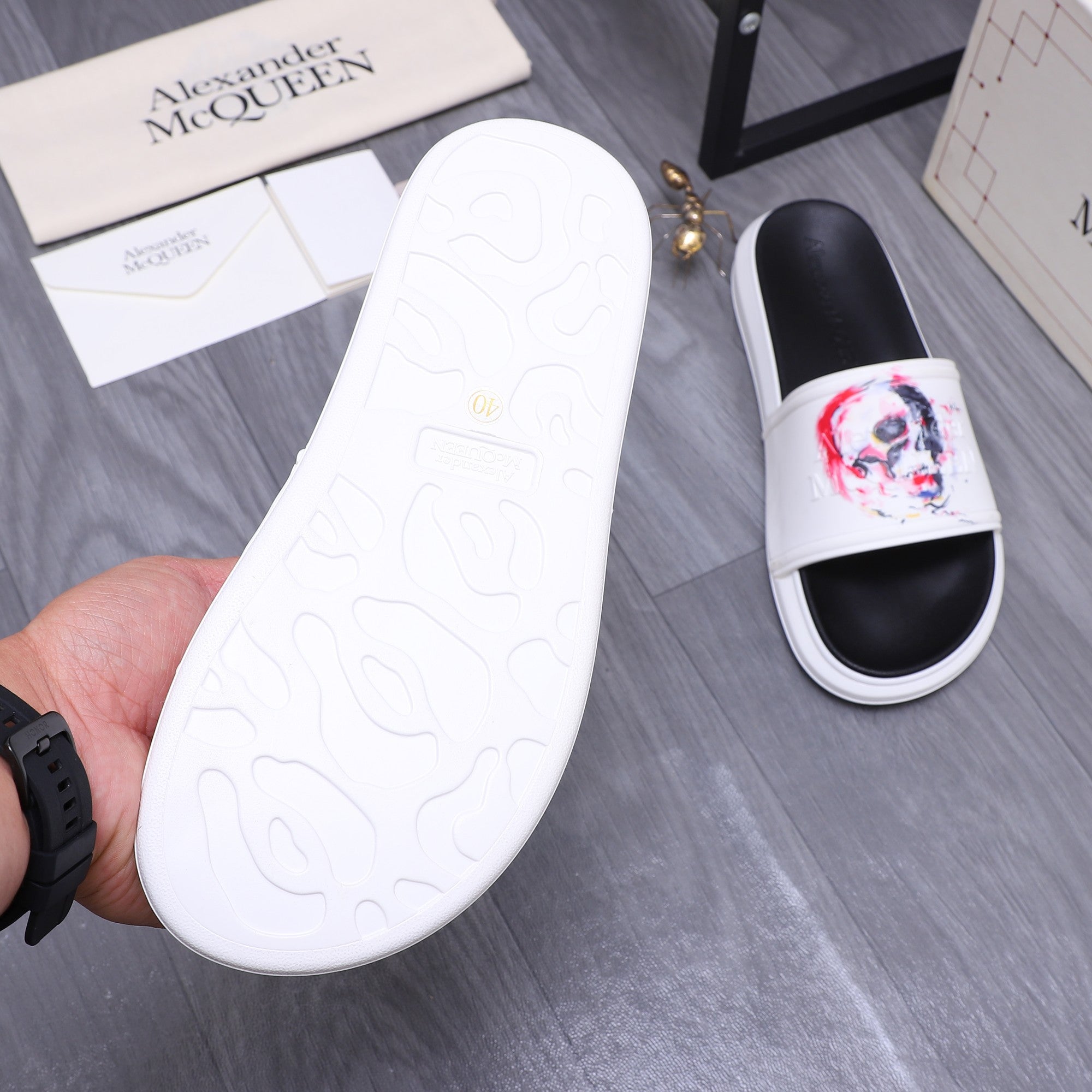 Alexander McQueen slide sandal outsole, white underside with embossed pattern logo
