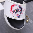 Alexander McQueen slide sandal close-up of white strap with red/blue skull print