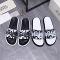 Alexander McQueen slide sandals with black and white graphic strap and white rubber sole