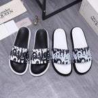 Alexander McQueen slide sandals with black and white graphic strap and white rubber sole