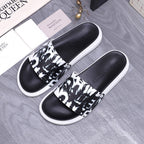 Alexander McQueen slide sandals with black leather upper, black-and-white graphic band