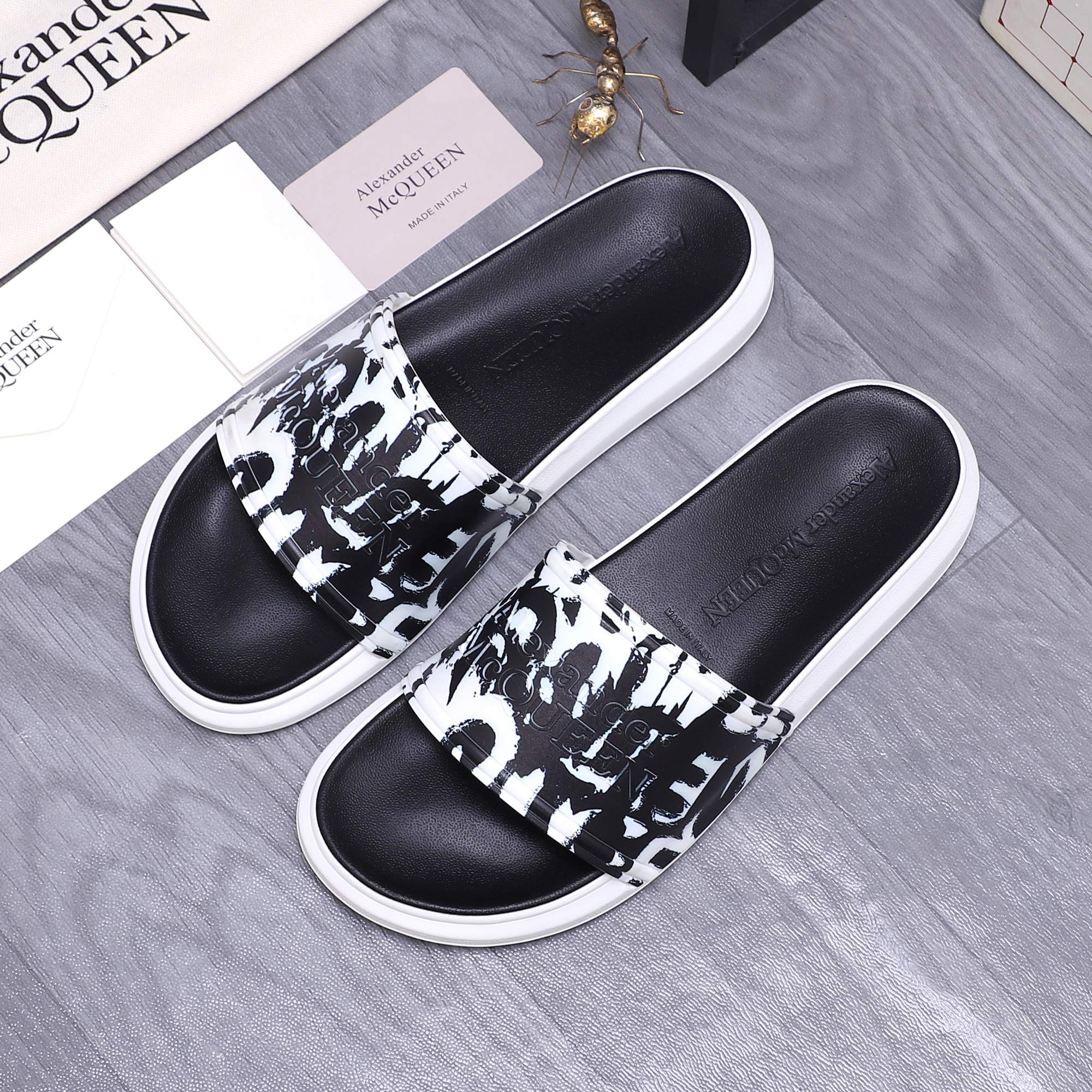 Alexander McQueen slide sandals with black leather upper, black-and-white graphic band