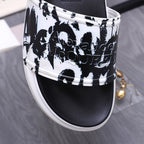 Alexander McQueen slide sandals close-up of black-and-white graphic upper and white edge