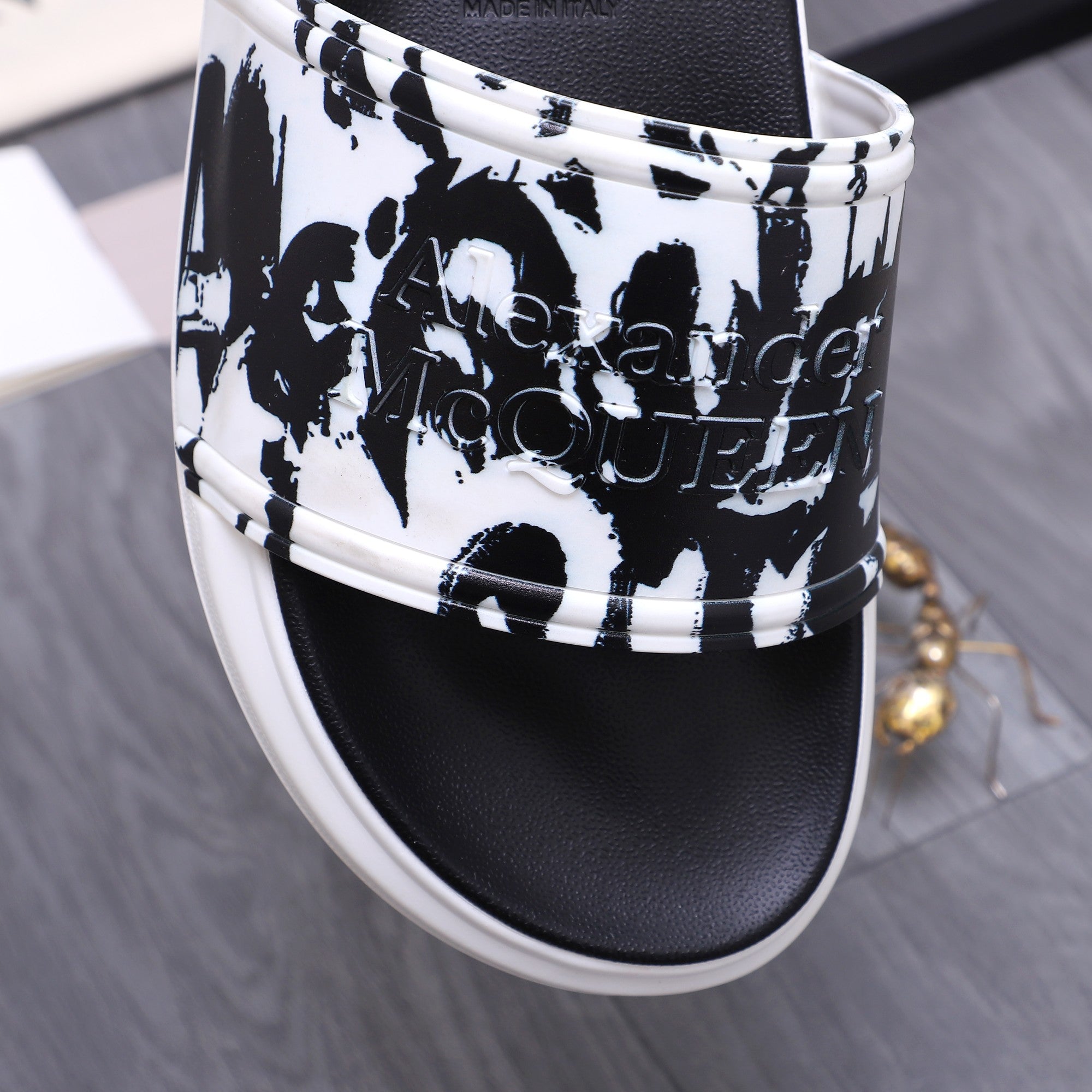 Alexander McQueen slide sandals close-up of black-and-white graphic upper and white edge