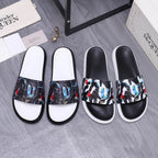 Black slide sandals with white footbeds and multicolor abstract printed straps