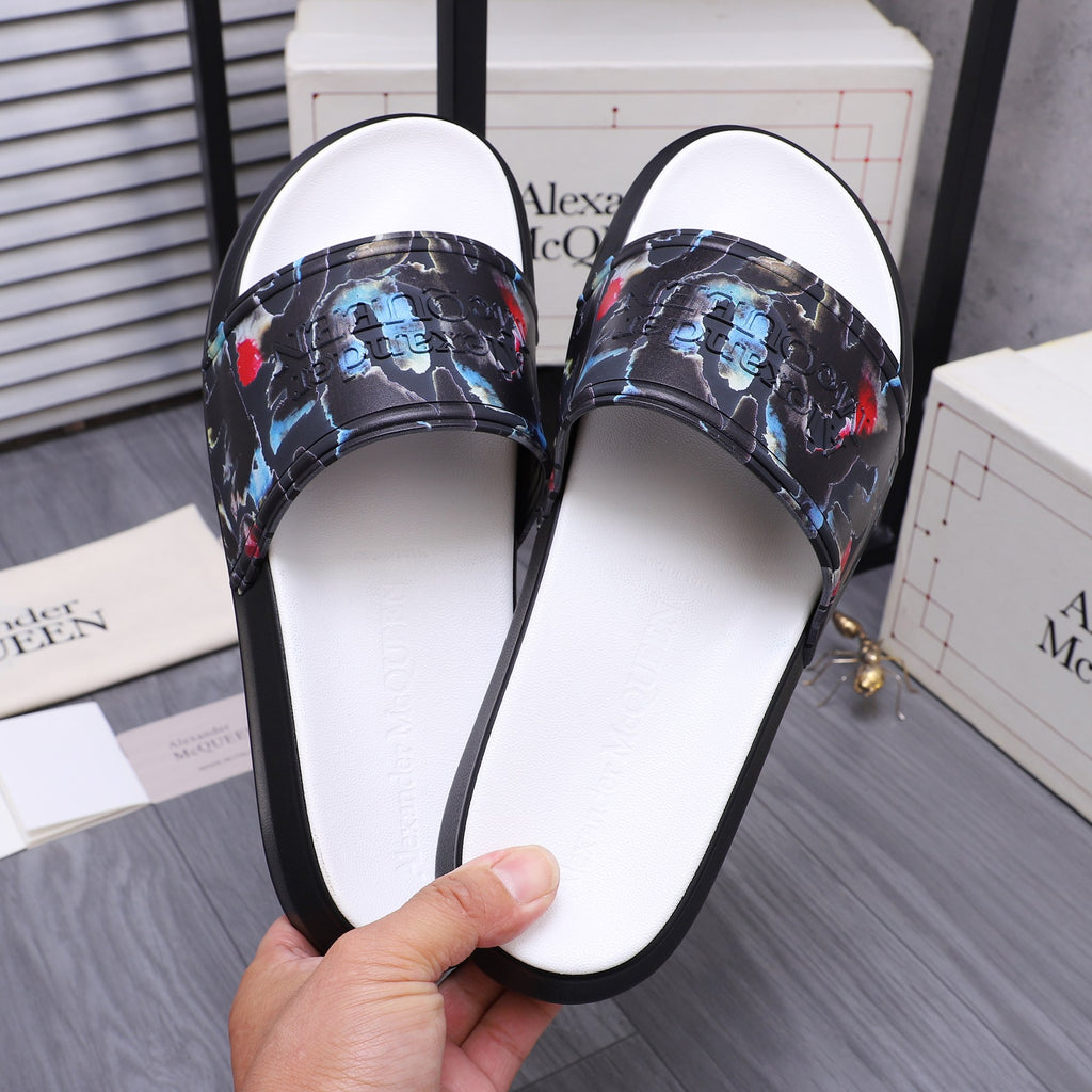 Front view of black slide sandals with white insoles and colorful abstract straps