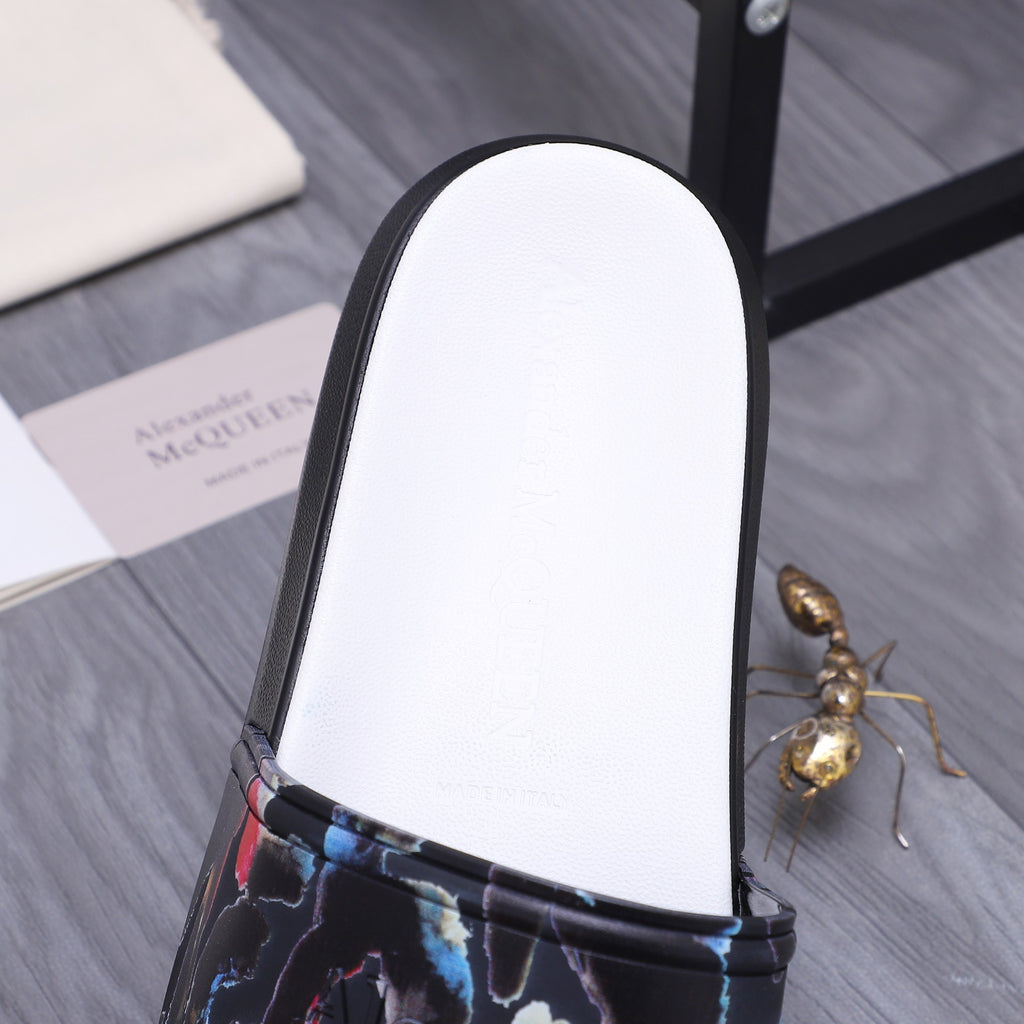 Close-up of black slide sandal with white footbed and multicolor abstract strap