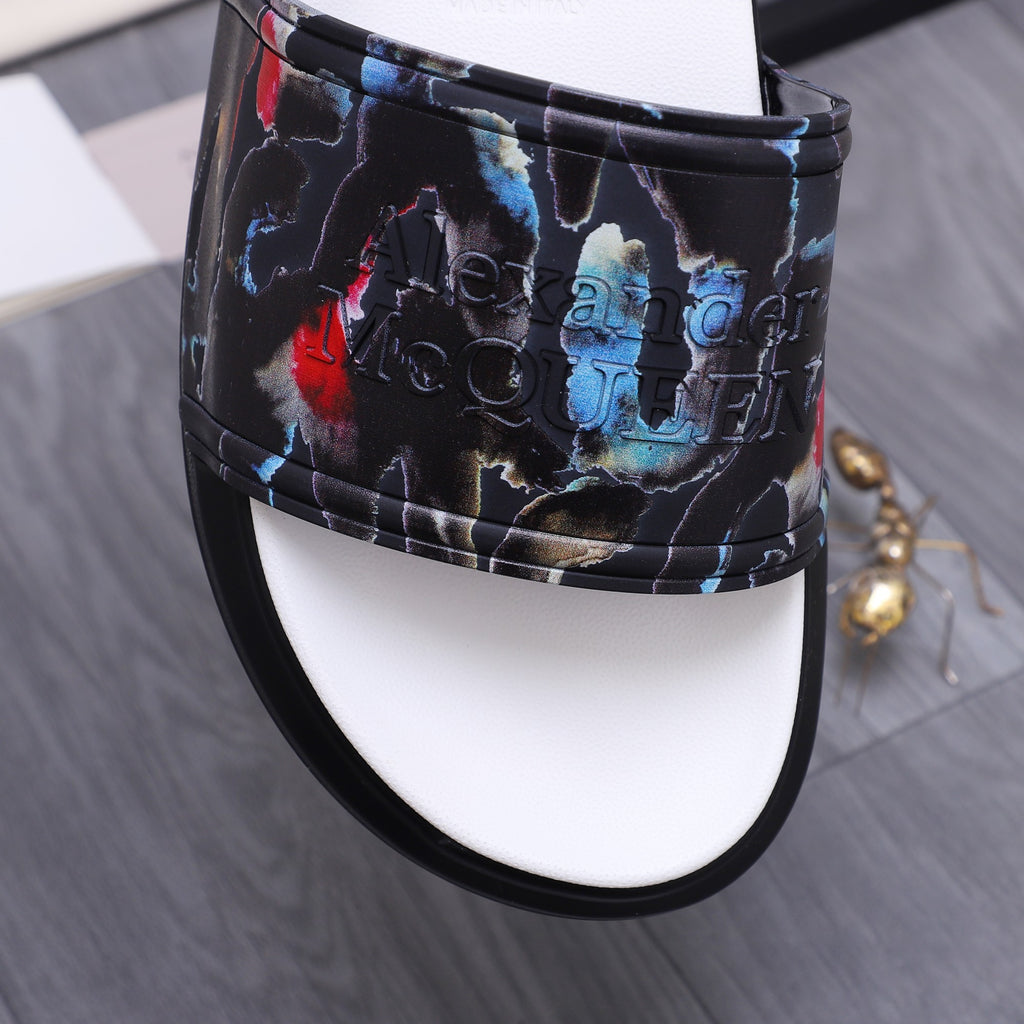 Close-up of black slide sandal strap with colorful abstract pattern and white sole edge