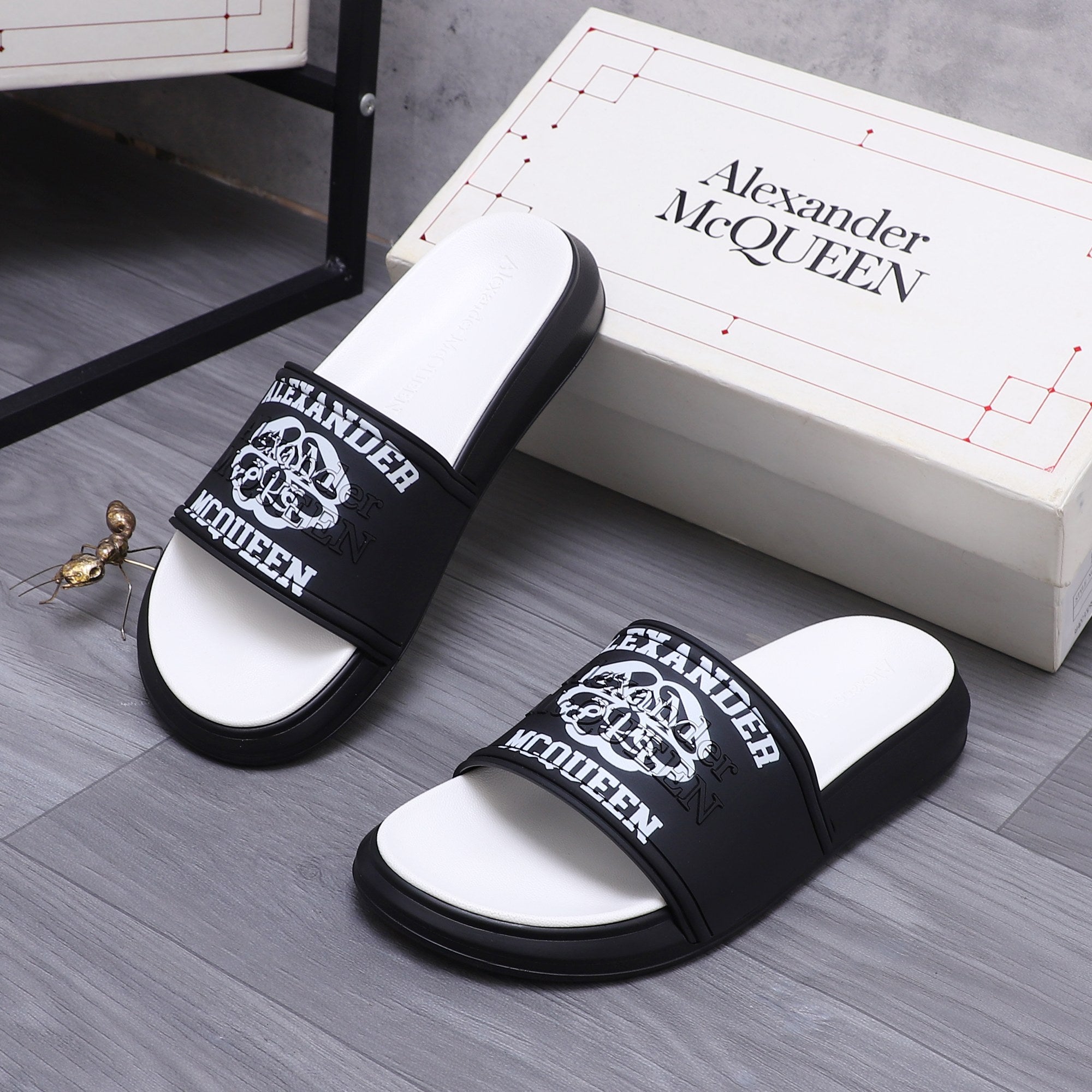Alexander McQueen slide sandals, black logo straps and white footbeds on display