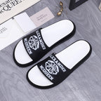 Alexander McQueen slide sandals, black logo straps with white footbeds, pair side view