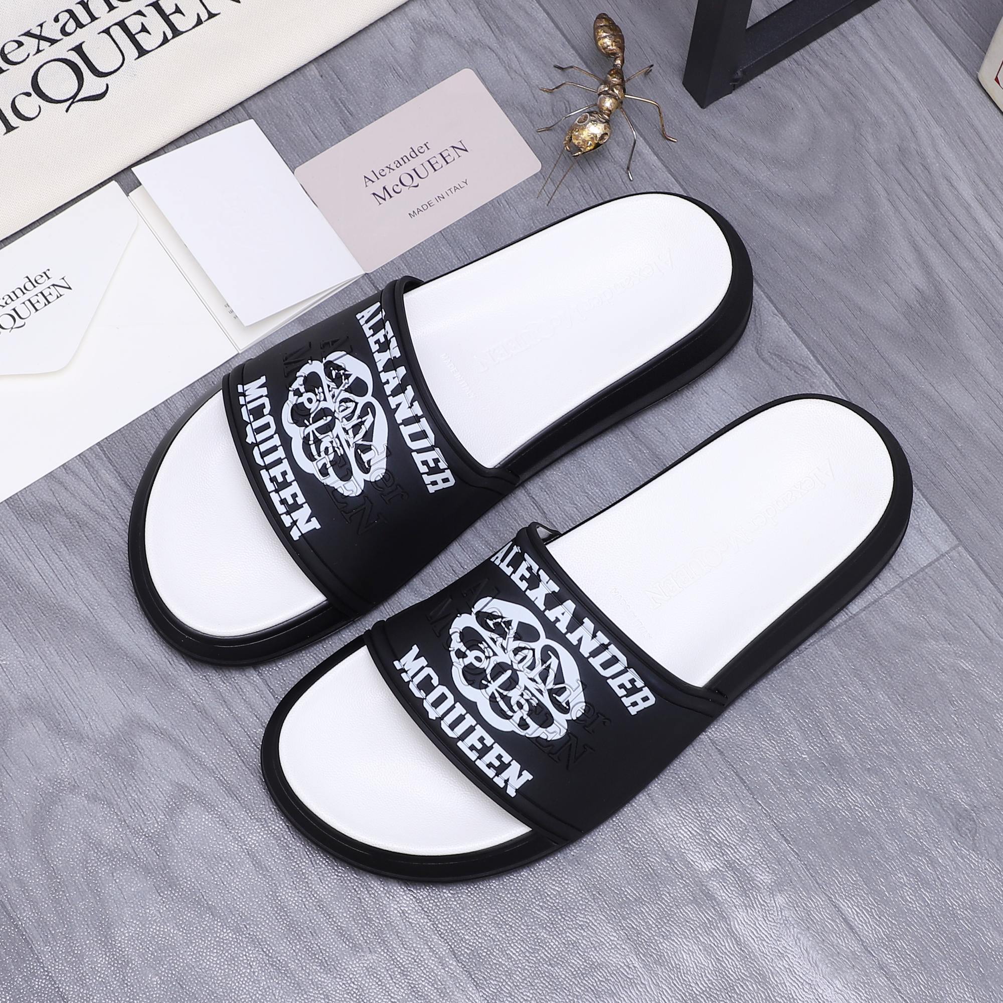 Alexander McQueen slide sandals, black logo straps with white footbeds, pair side view