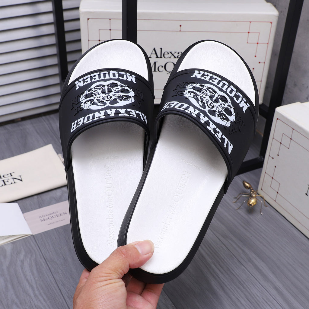 Alexander McQueen slide sandals close-up, black logo strap and white sole