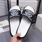 Alexander McQueen slide sandals close-up, black logo strap and white sole