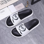 Alexander McQueen slide sandals with white straps and black interior, MC logo print