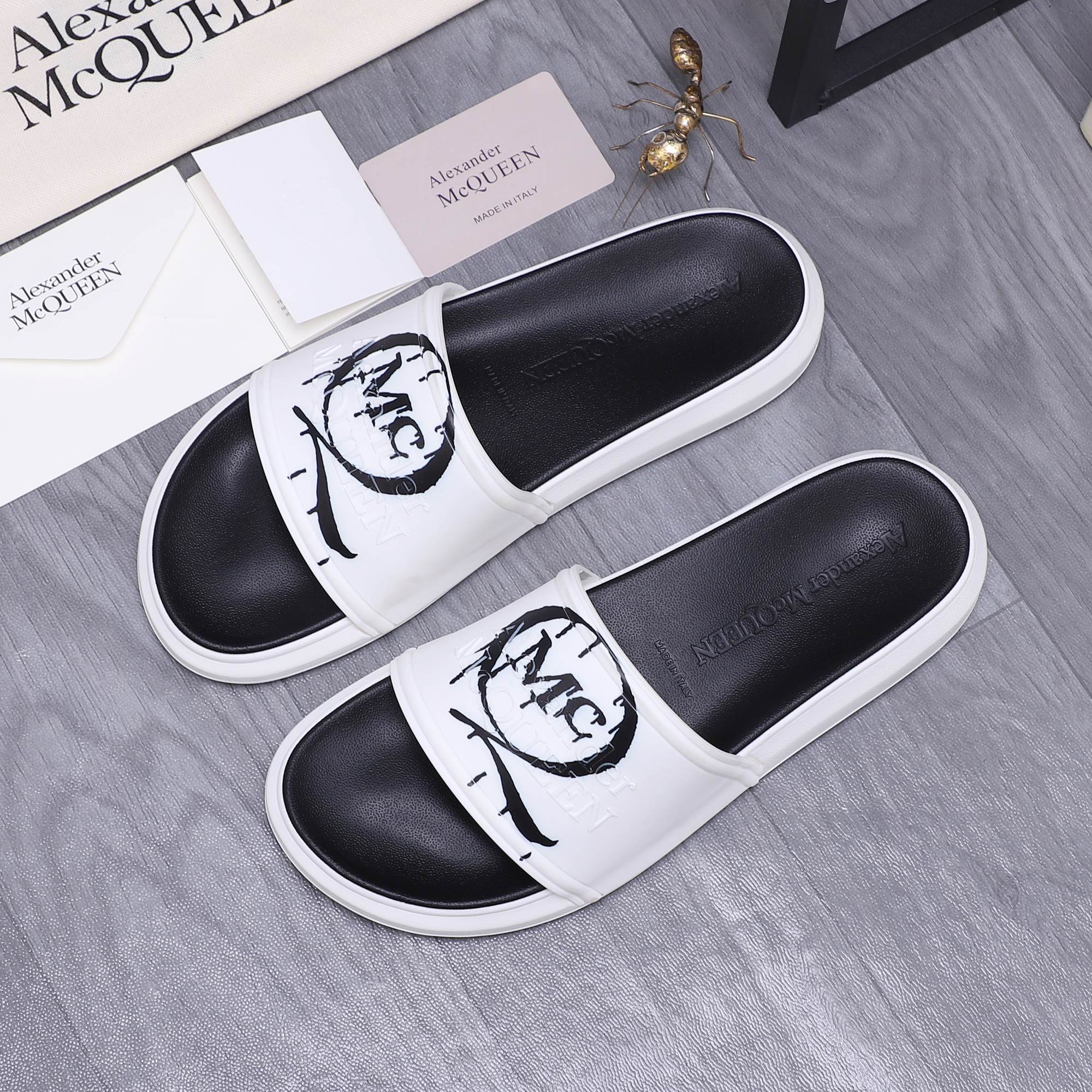 Alexander McQueen slide sandals with white straps and black interior, MC logo print