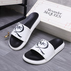 Alexander McQueen slide sandals, black footbed with white strap and MC logo detail