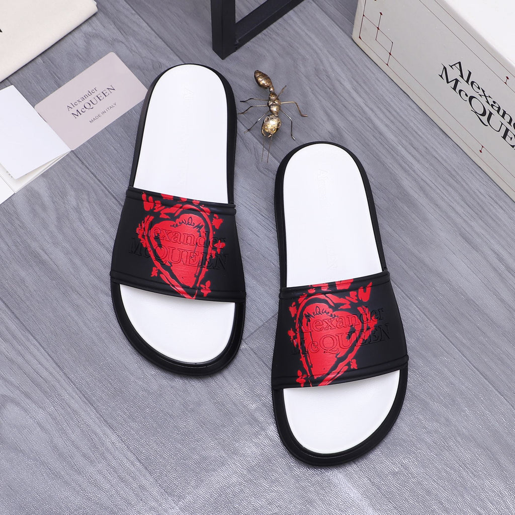 Black slide sandals with red face-style graphic strap and white footbed panels