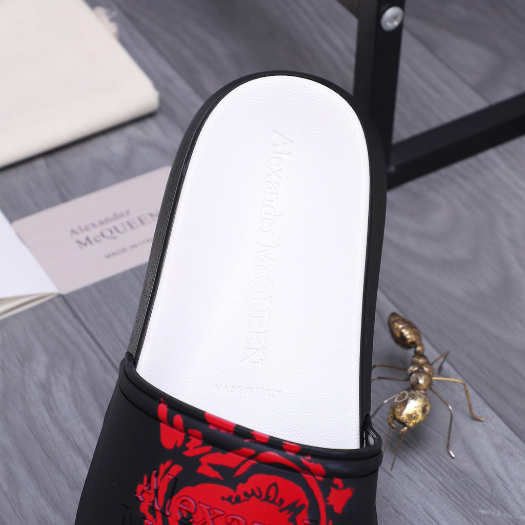 Close-up of white footbed with embossed text and black slide strap with red graphic