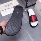 Black rubber slide sandal outsole with textured pattern and red-printed strap