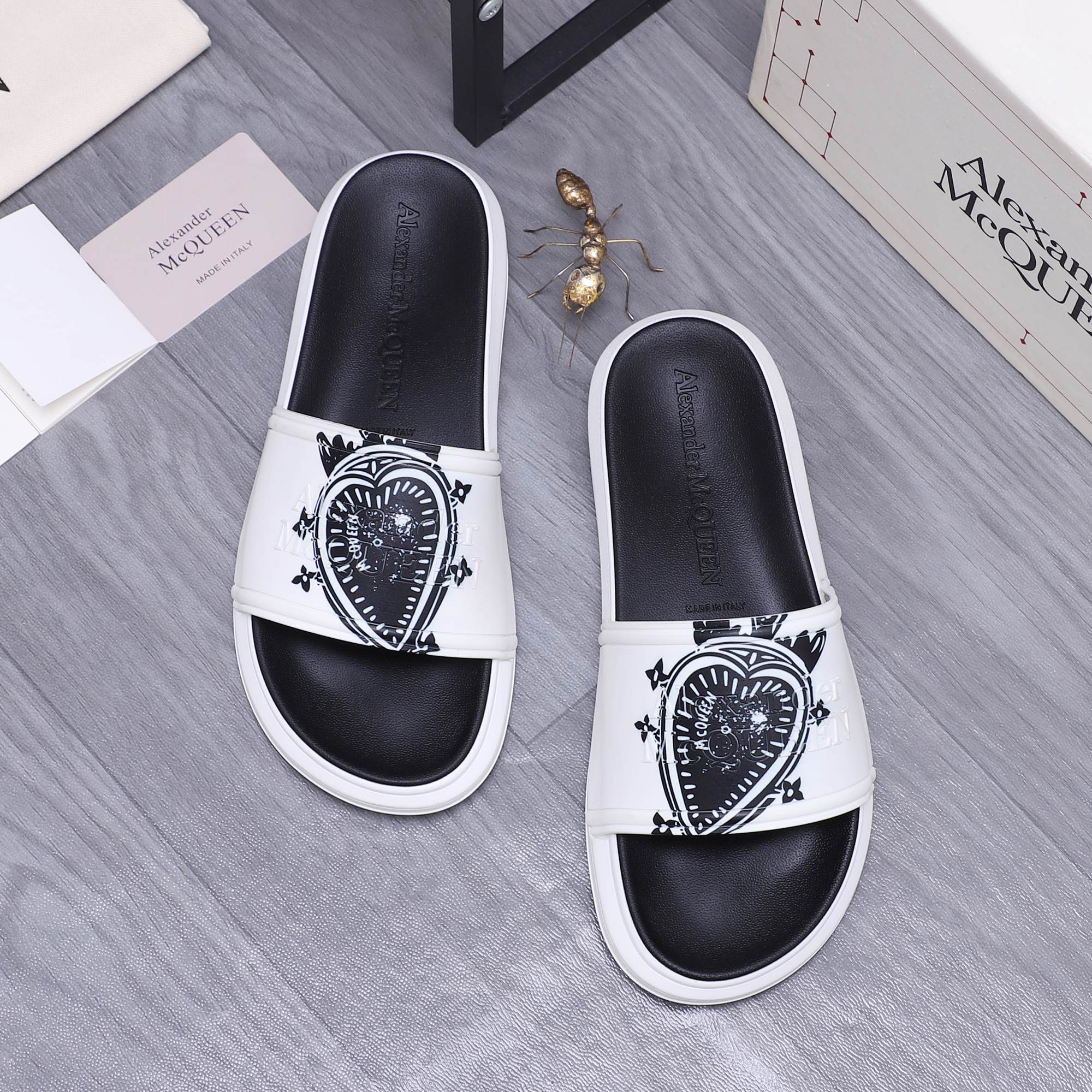 Alexander McQueen slide sandals, white strap with black crest emblem, black footbed