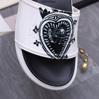 Alexander McQueen slide sandals, close-up of white strap with black crest graphic
