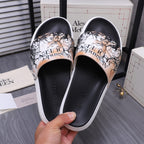 Alexander McQUEEN slide sandals close-up: black uppers with beige graphic pattern and white trim