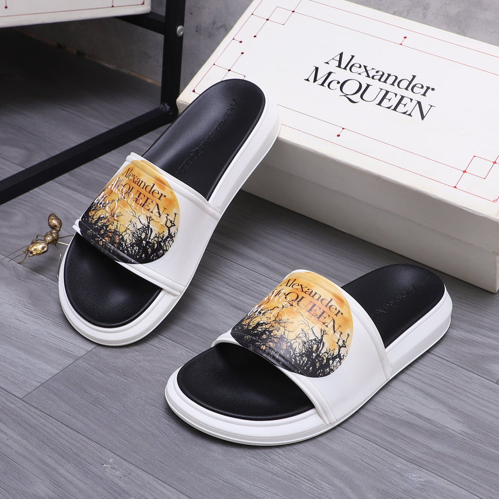 Alexander McQueen slide sandals, black footbeds, white straps, gold graphic print.