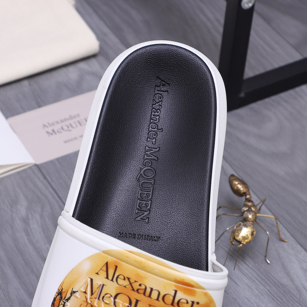 Alexander McQueen slide sandal footbed close-up, black insole with brand embossing.