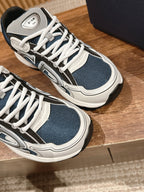 Close-up of dark blue and white lace-up sneakers with layered panels and logo patch