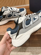 Side view of Dior low-top sneakers in dark blue and white with white rope laces