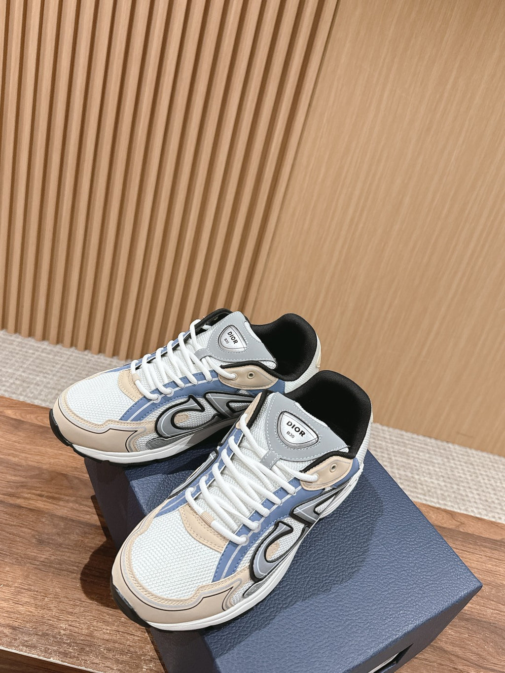 Dior low-top sneakers with white laces, blue side details, and gray and tan trim