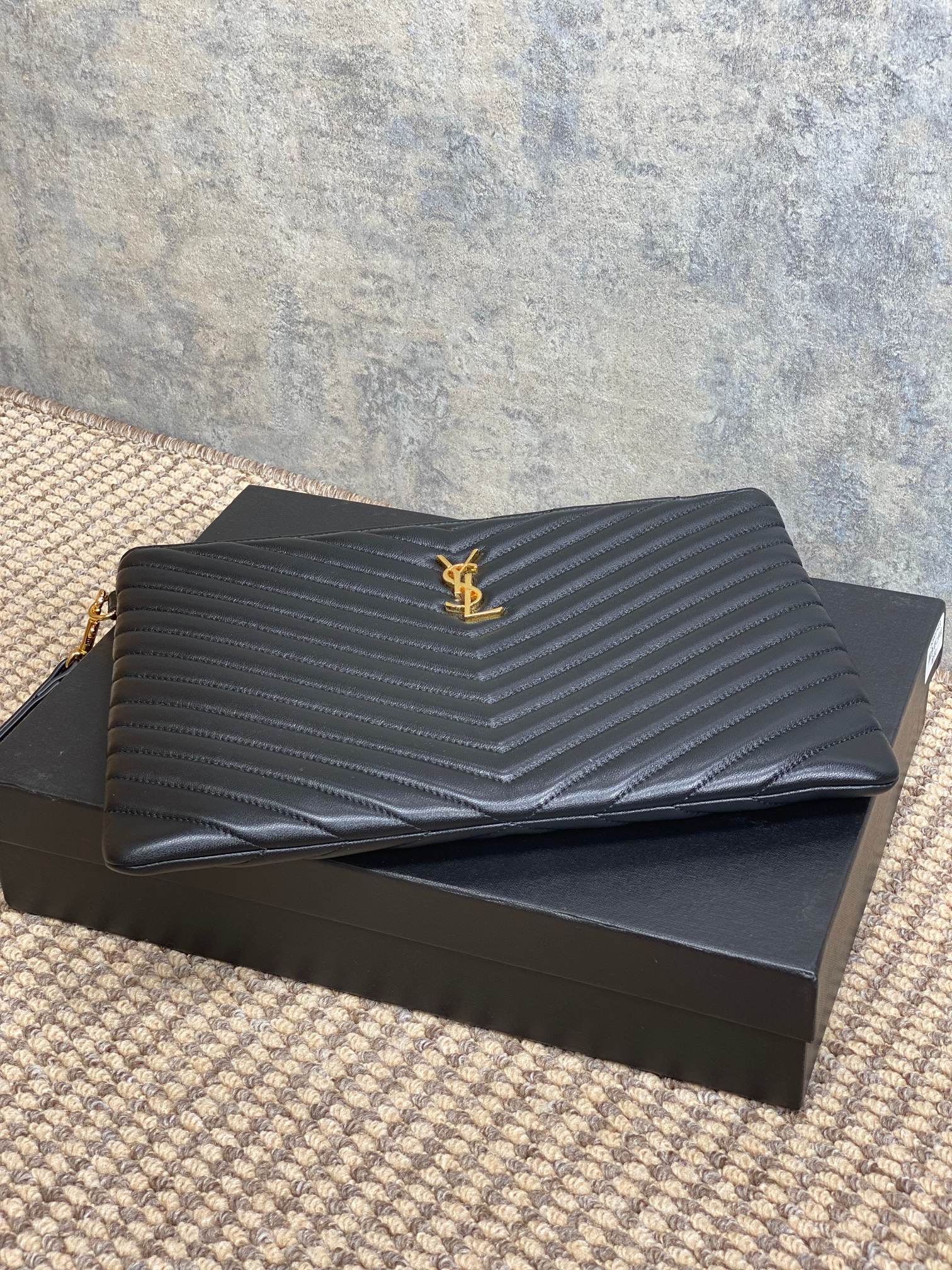 Dark chevron-quilted Saint Laurent clutch with top YSL logo