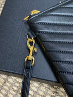 Close-up of gold zipper hardware and attached dark blue chain strap