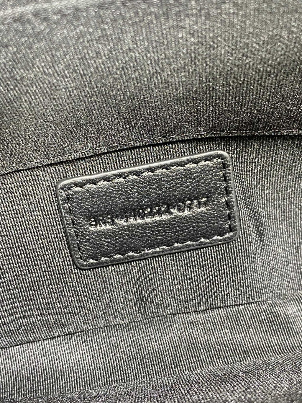 Dark fabric exterior with stitched brand label patch
