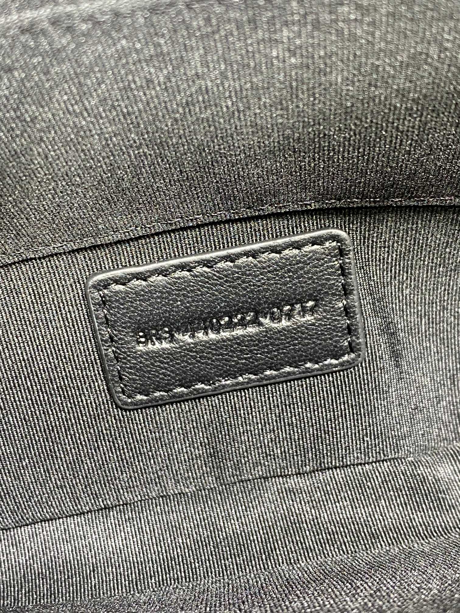 Dark fabric exterior with stitched brand label patch